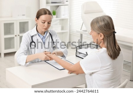 Arthritis symptoms. Doctor examining patient's wrist in hospital Royalty-Free Stock Photo #2442764611