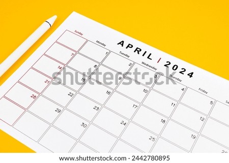 April 2024 desk calendar and pen on yellow color background. Time planning day concepts.