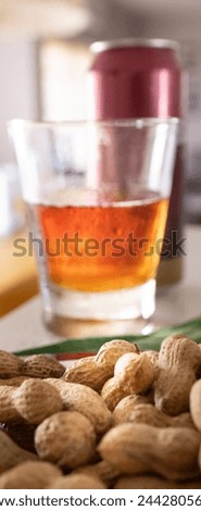 Fresh beer and peanuts in the foreground., ideal for a summer aperitif.Vertical picture