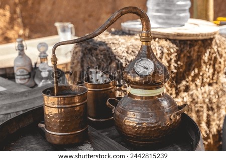 Artisan distillation: the timeless craft of a copper alembic still poised atop an aged wooden barrel Royalty-Free Stock Photo #2442815239
