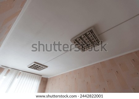 Texture or background, wallpaper of a white celing with daylight lamps in a public institution during the day.