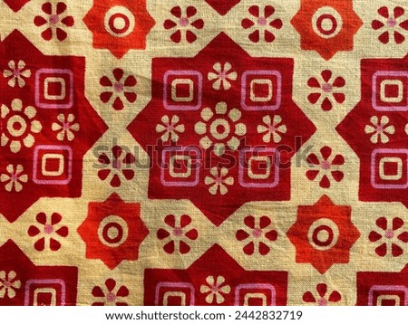 Geometric floral block printed in red and maroon on cream cotton fabric