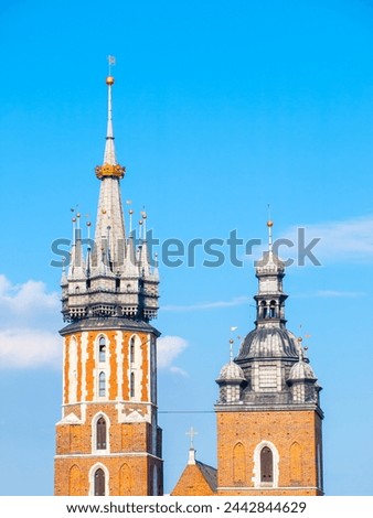 The picturesque towers of Saint Mary Church in Krakow stand tall, showcasing Gothic architecture under a clear blue sky. Krakow, Poland