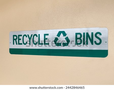 Recycle bins sign on wall. Sign indicating location of consumer recycling collection point.