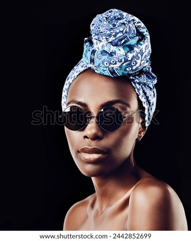 Portrait, fashion and sunglasses with African woman in studio isolated on black background for heritage. Aesthetic, face and tradition with confident young person in trendy headwear for style culture Royalty-Free Stock Photo #2442852699