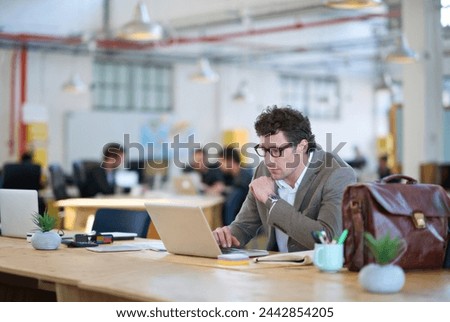 Laptop, employee and man typing with glasses for sales in startup, business and corporate company. Workplace, bookkeeper and male person working with technology, online and internet in office