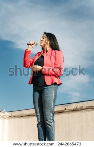 Pop singer singing with a microphone on the roof