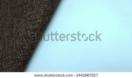 Close up of brown fabric on blue background with copy space for text