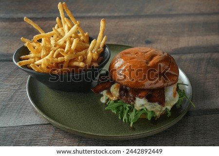 cheeseburger with fries on a wooden background