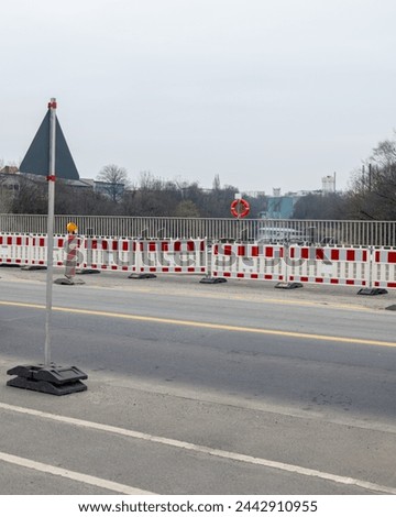 Road on a bridge with construction sign, fence an life vest