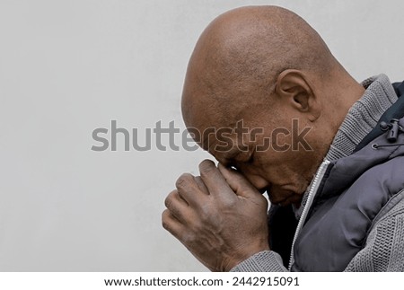 praying to god with hands together Caribbean man praying with grey background stock image stock photo