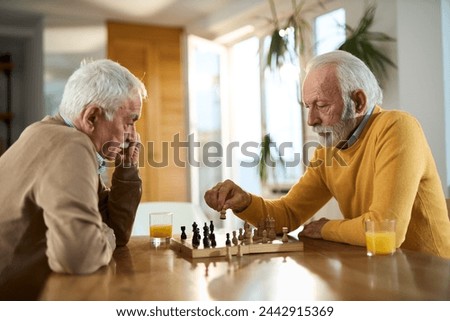 Mature men playing chess while relaxing at home