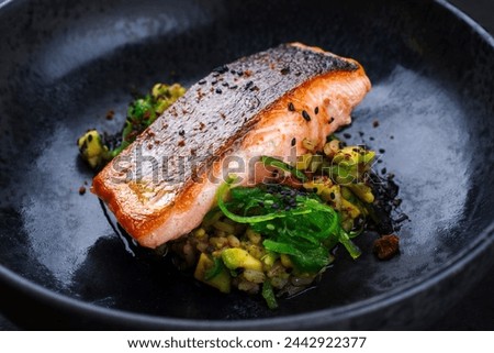 Traditional Japanese gourmet salmon fish steak tataki with chopped avocado, rice and wakame served as close-up on a design bowl  Royalty-Free Stock Photo #2442922377