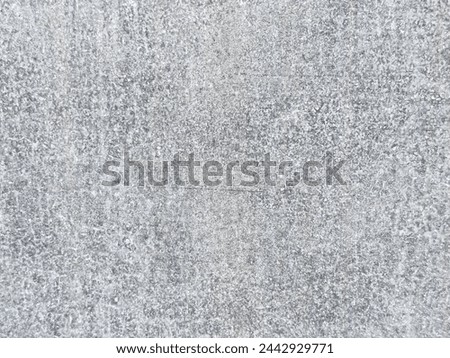 Close-up of a light gray concrete surface. The smooth texture of the concrete has a mottled appearance with slight variations in color
