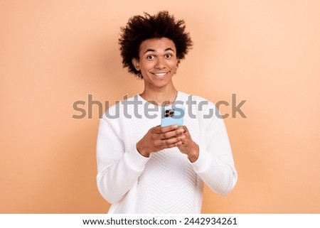 Photo of positive attractive man wear white trendy clothes hold modern device gadget isolated on beige color background