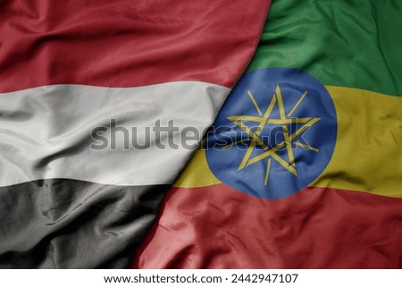 big waving national colorful flag of ethiopia and national flag of yemen . macro