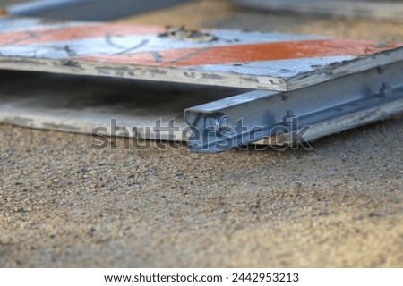 orange and white striped construction sign knocked down on ground