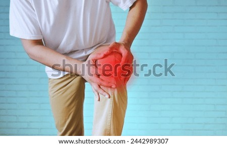Joint pain, Arthritis and tendon problems. a man touching nee at pain point, on white background. Knee pain point shown in red. Royalty-Free Stock Photo #2442989307
