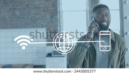 Image of media icons over happy african american businessman talking on smartphone in office. Global business, technology and digital interface concept digitally generated image.