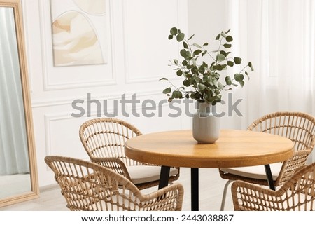 Dining room interior with comfortable furniture and eucalyptus branches