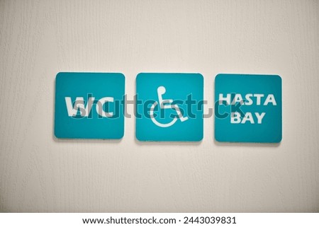 Restroom sign for disable people on a white wooden door.