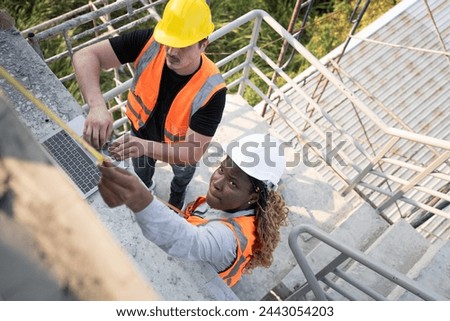 Worker engineer African woman working with caucasian worker at construction site	