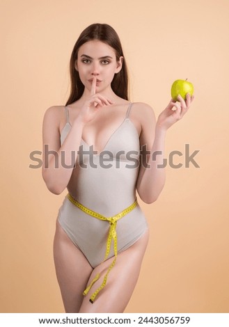 Secret diet. Young woman measuring waist. Weight loss diet. Slim waist, apple and measuring tape. Weight loss and dieting. Diet for waistline. Fit Body. Dieting for Waist and belly. Healthy diet. Royalty-Free Stock Photo #2443056759