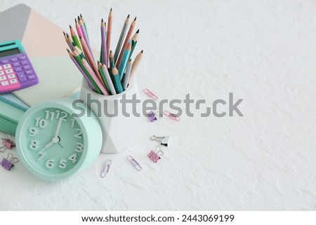 Alarm clock and stationery on white background