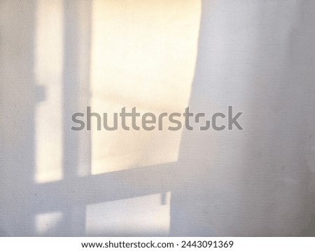 Dappled light and shadow from a window frame against a wall. Partial focus, blurred picture. Background, texture, pattern, frame, place for text