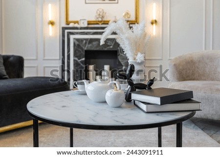 close-up of a tea table setting in a modern living room with a marble fireplace in a chic bright interior of a huge apartment without people during the daytime