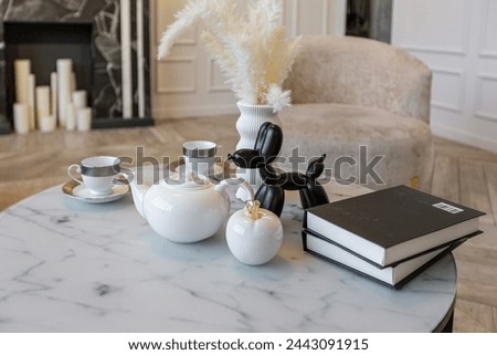 close-up of a tea table setting in a modern living room with a marble fireplace in a chic bright interior of a huge apartment without people during the daytime