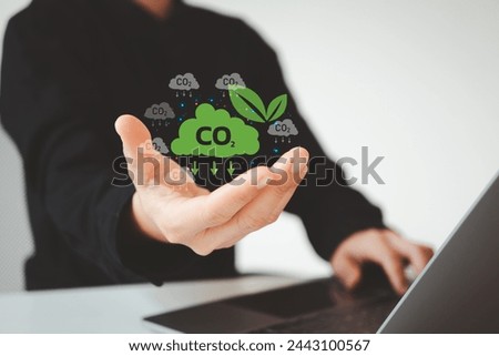 Reduce CO2 emissions concept. Climate change to limit global warming and sustainable development and green business. Businessman use laptop with carbon reduction icon on virtual screen.