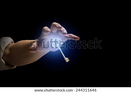 Close up of human hand catching golden key
