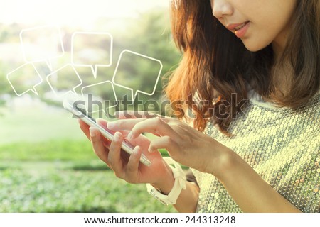 beautiful woman playing and touching on smart phone screen in outdoor of home garden field Royalty-Free Stock Photo #244313248