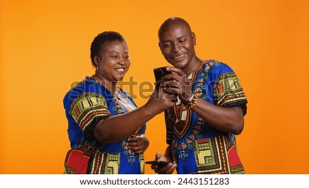 African american couple checking social media network on smartphone app, reading their messages on internet connection. Man and woman using mobile phone to scroll on websites.