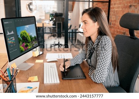Graphic designer woman working in office, using photo editor software
