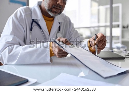 Side view closeup of doctor showing clipboard with document to patient and pointing with pen copy space