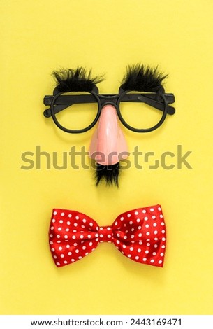 April Fool's Day clowning props. Clown costume accessories on yellow background