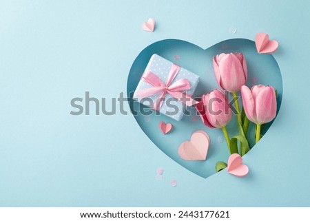 Deluxe Mother's Day snapshot, viewed from the top: tulips, a present adorned with a silk ribbon, paper hearts, and fashionable confetti through heart frame on a pastel blue background, space for text Royalty-Free Stock Photo #2443177621