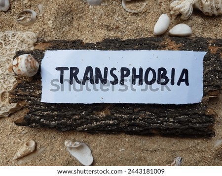 Transphobia writting on beach sand background. Royalty-Free Stock Photo #2443181009
