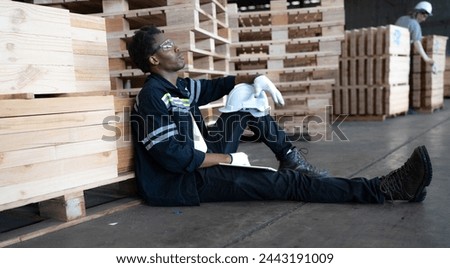 Multiracial engineer, worker sitting resting on floor feel tired from overworked in factory. Young adult technician feel weak, stress, exhausted, worried, frustrated, unhappy, hopeless, or headache Royalty-Free Stock Photo #2443191009