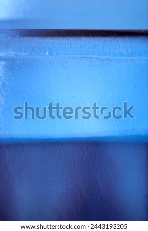A close-up view of a blue glass object, highlighting the textured surface that creates a visually engaging pattern