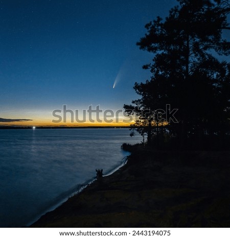 Comet Neowise in the night sky over the lake and Noctilucent clouds.