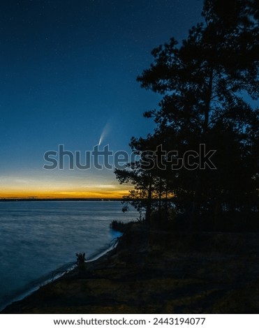Comet Neowise in the night sky over the lake and Noctilucent clouds.