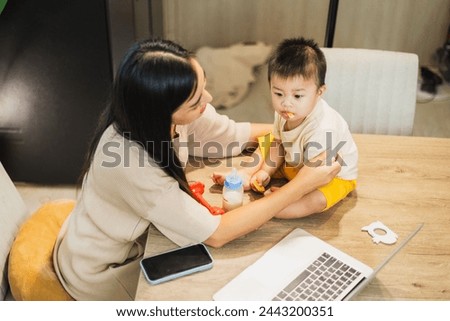 The happiness of mother and child being together every moment. warm family pictures While mother is working from home.