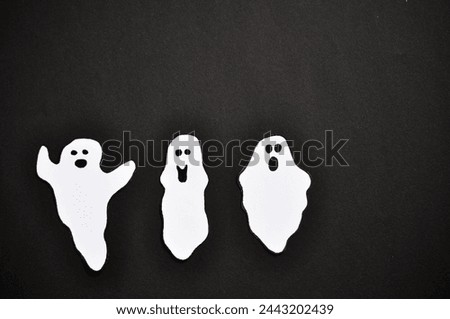 white ghosts on a black background - happy halloween