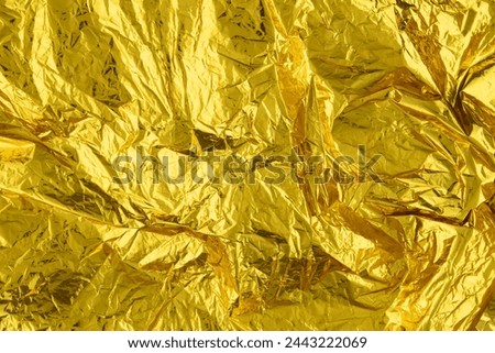 Texture of crumpled gold foil paper.