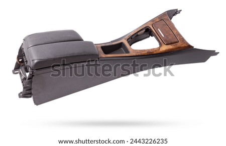 Plastic element of car interior is covered in black leather and wooden - armrest or a glove compartment - spare part with air conditioning holes on a white background. Catalog for site. Royalty-Free Stock Photo #2443226235