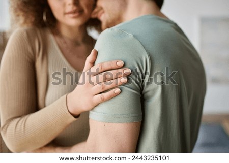 Cropped image of couple in love, woman touching shoulder of her boyfriend at home
