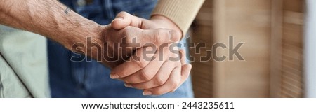 Cropped view closeup image of couple in love holding hands. Symbol sign sincere feelings, banner